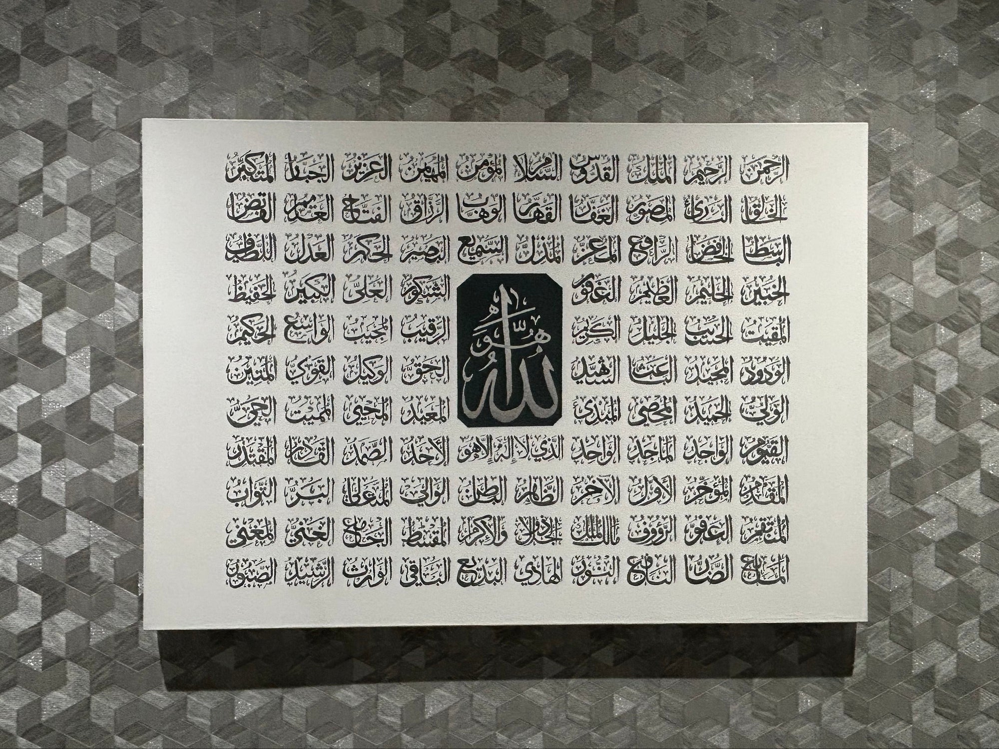 Asma ul husna
Sheet of calligraphy with Arabic text and a logo on a textured gray background