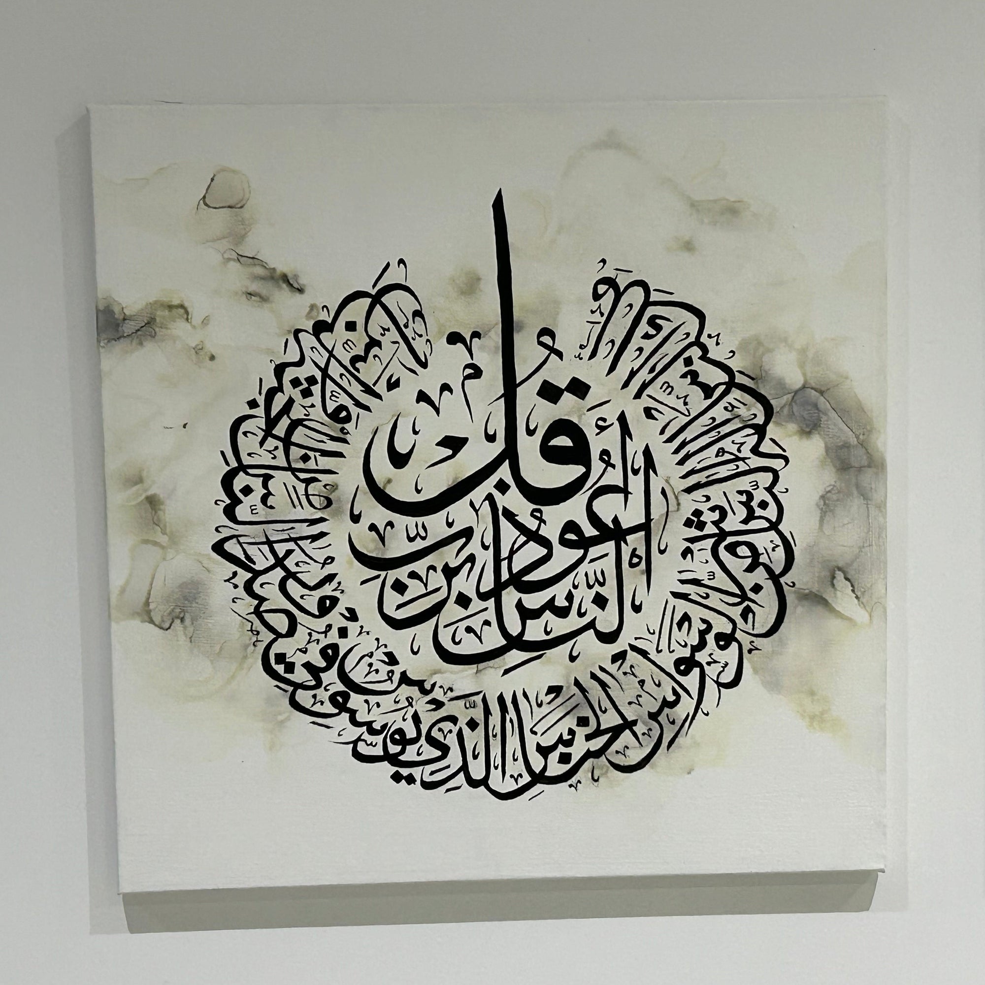 Decorative wall art with Arabic calligraphy on a light background