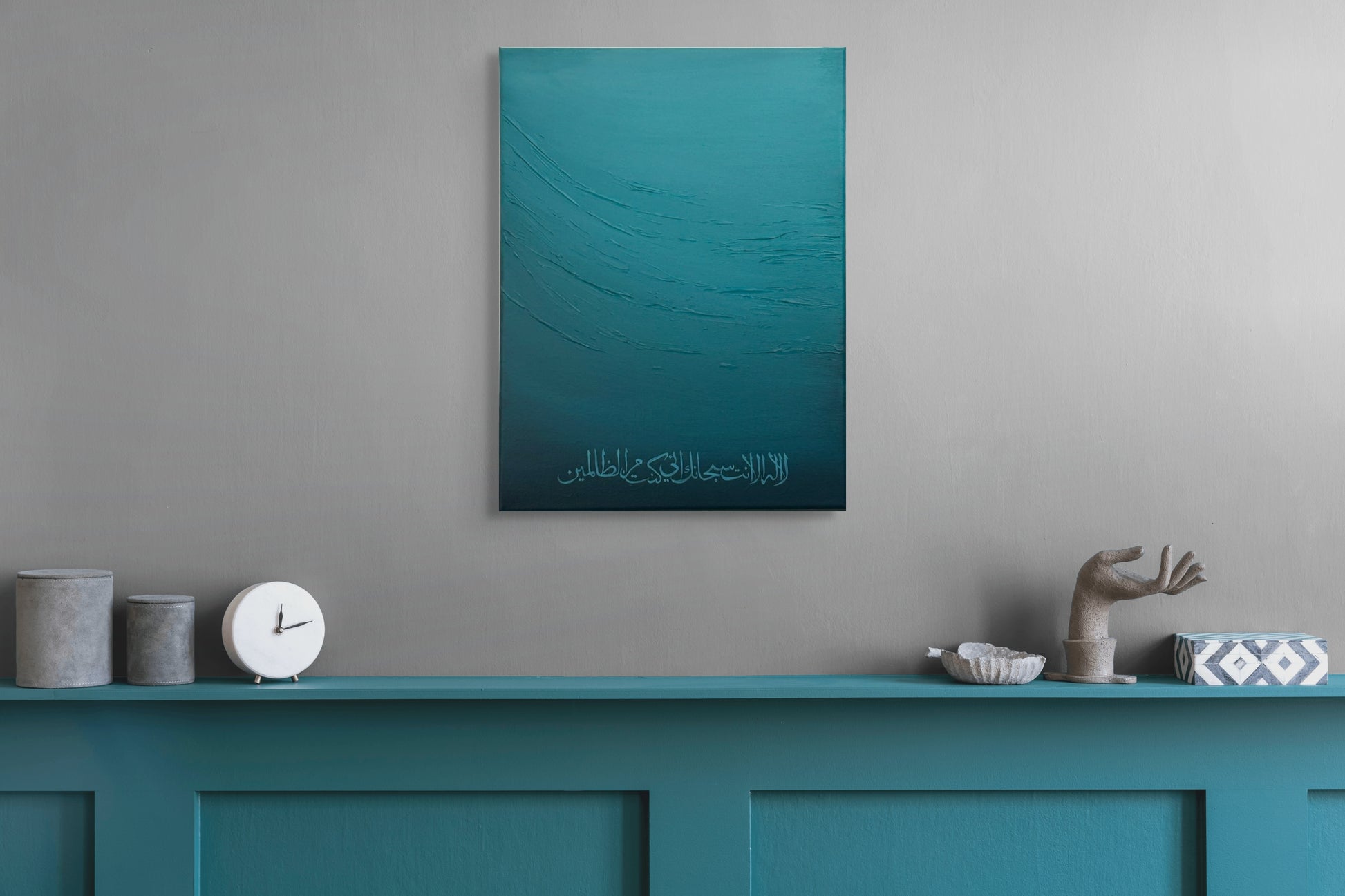 Teal abstract painting on a gray wall above a teal console table with decorative items.